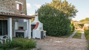une maison avec un four extérieur dans la cour dans l'établissement Welcomely - Acqua e Tramonto, à Olbia