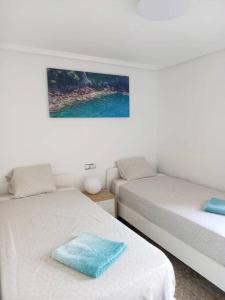 Marbella Sea View Apartament في آريناليس ديل سول: غرفة بسريرين وصورة على الحائط