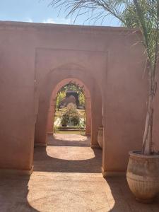 - un couloir avec une arche et une usine dans l'établissement Villa Pauline with private pool & garden, hotel service and no insight., à Marrakech