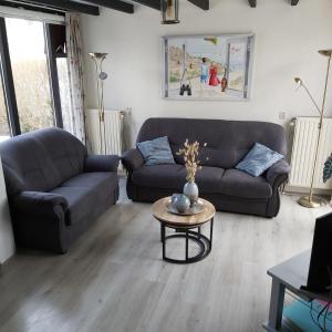 a living room with a couch and a table at Klepperstee Esdoorn 3 in Ouddorp