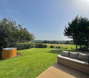 a couch sitting on a deck in the grass at The Perch in Bridgend