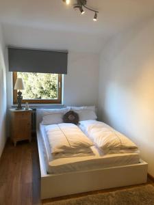 a bed with a cat sitting on it in a bedroom at Alpsoul eine Ferienwohnung mit Charisma…. in Garmisch-Partenkirchen