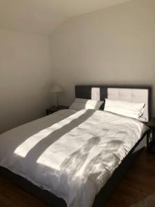 a bed with white sheets and pillows in a bedroom at Alpsoul eine Ferienwohnung mit Charisma…. in Garmisch-Partenkirchen