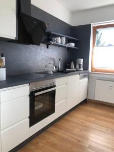 a kitchen with white cabinets and a stove top oven at Alpsoul eine Ferienwohnung mit Charisma…. in Garmisch-Partenkirchen