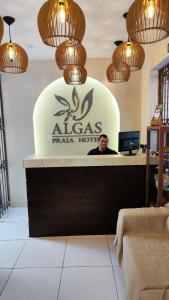 een man die aan een receptie zit in een restaurant bij Algas Praia Hotel in Fortaleza