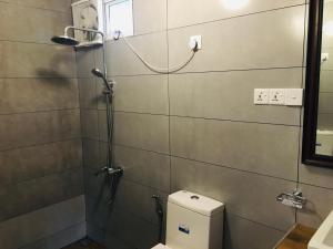 a bathroom with a shower with a toilet in it at Aquaa Leaf Residences in Nuwara Eliya