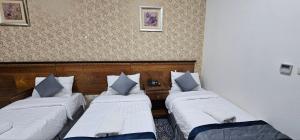 duas camas num quarto de hotel com duas em فندق إي دبليو جي العزيزية em Meca
