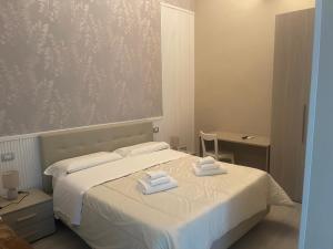 ein Schlafzimmer mit einem Bett mit zwei Handtüchern darauf in der Unterkunft B&B Chez Moi in Neapel