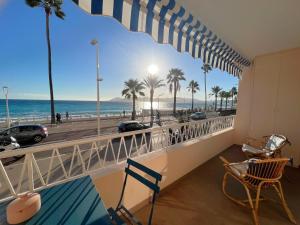 uma varanda com vista para a praia e palmeiras em Marjolaine luxury sea view, by Welcome to Cannes em Cannes