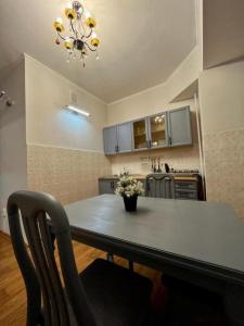 cocina con mesa de comedor y lámpara de araña en Апартаменты MOON APARTMENTS - ZENKOVA 86, en Almaty