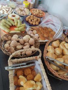una mesa con cestas llenas de diferentes tipos de alimentos en Chalés Ipê do Lago, en Capitólio