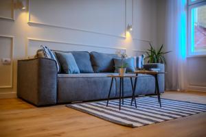 sala de estar con sofá azul y mesa en Porta Apartments Novi Sad en Novi Sad