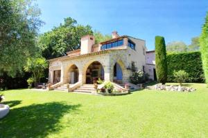 une grande maison avec une grande cour avec de l'herbe dans l'établissement Villa Provençale 300 m2 proche Nice, cannes piscine chauffée 6 chambres 5sdb privatives, à Le Rouret