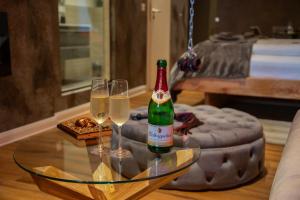 a bottle of champagne and two glasses on a glass table at exkl. romantisches SM Apartment Black Rose in Gifhorn