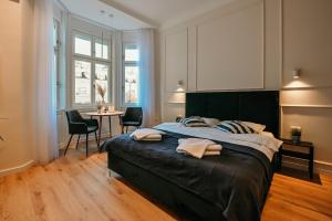 Porta Apartments Novi Sad في نوفي ساد: غرفة نوم بسرير كبير وطاولة مع كراسي