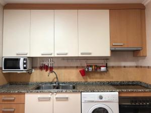 una cocina con fregadero y microondas en A la Vera de Alarcón, en Motilla del Palancar