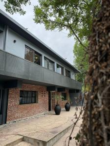 a brick building with two vases in front of it at Nuevo Hotel Ciervo de Oro- By HVH in Villa Carlos Paz