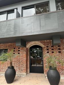 two large black vases sitting in front of a building at Nuevo Hotel Ciervo de Oro- By HVH in Villa Carlos Paz