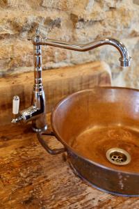 un lavandino in rame con rubinetto su un bancone in legno di Le Nid de la Breizhidence a Combourg
