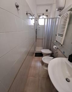 a white bathroom with two toilets and a sink at Casa Carlo apartment with parking near the center in Bari