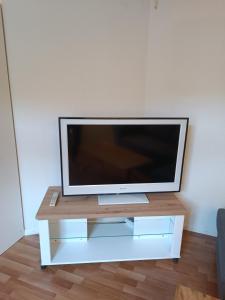 a flat screen tv sitting on a white tv stand at Apartment Jolie in Interlaken