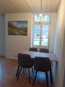Apartment Jolie في إنترلاكن: طاولة طعام مع كراسي ونافذة