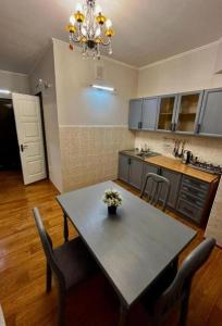 cocina con mesa con sillas y comedor en Апартаменты MOON APARTMENTS - ZENKOVA 86, en Almaty