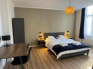 een slaapkamer met een bed, een tafel en een bureau bij Lusia Apartment in Jarosław