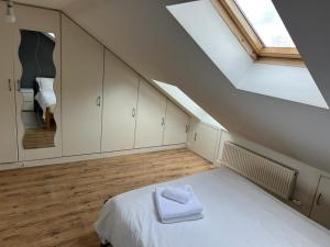 a attic bedroom with a white bed and a window at Private Studio Room With Your Shower and Kitchen in London