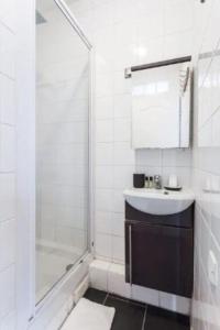 a white bathroom with a sink and a shower at CMG - Résidence Edouard Vaillant in Pantin