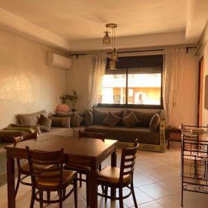 a living room with a table and a couch at Appartement Premium Village, 5 piscines in Marrakesh