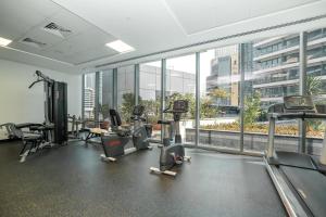 een fitnessruimte met loopbanden en cardio-apparatuur in een gebouw bij Luton Vacation Homes -Silverene Tower Full marina view ,Dubai Marina A50AB7 in Dubai