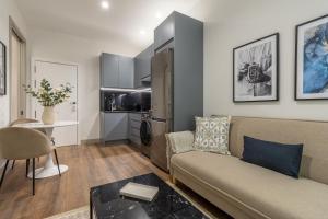 een woonkamer met een bank en een tafel bij 2 single beds in Chamberi Quevedo III in Madrid