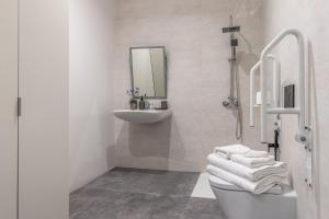 een witte badkamer met een wastafel en een toilet bij 2 single beds in Chamberi Quevedo III in Madrid