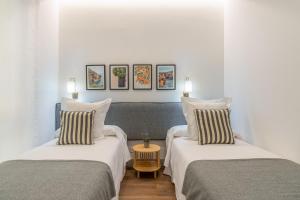 twee bedden in een kamer met witte muren bij 2 single beds in Chamberi Quevedo III in Madrid