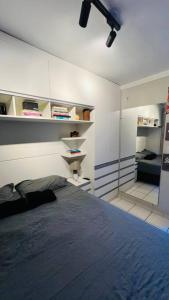 サンルイスにあるApartamento Home Practice Flatの棚付きの部屋にベッド1台が備わるベッドルーム1室