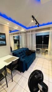 - un salon avec un canapé bleu et une table dans l'établissement Apartamento Home Practice Flat, à São Luís