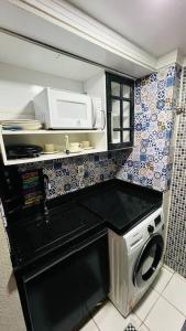 a kitchen with a washing machine and a microwave at Apartamento Home Practice Flat in São Luís
