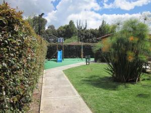 un jardín con un parque infantil con una cama elástica azul en Apartamento terrazas de cajica, en Cajicá