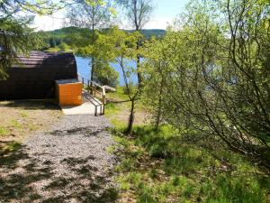 a small building next to a body of water at Kendoon Cabin in Carsphairn