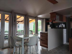 uma cozinha e sala de jantar com mesa e cadeiras em MOBIL HOME LE LOZERIEN em Valras-Plage