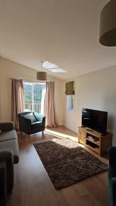 a living room with a flat screen tv and a couch at Two Bedroom Lodge In The Country - Owl, Peacock & Meadow in Liskeard