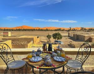 a table with food and drinks on top of a desert at Dar Duna in Adrouine