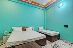 a blue room with a bed and a chair in it at OYO Green Valley Guest House in Sultānpur