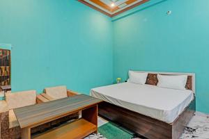 a blue room with a bed and a table at OYO Green Valley Guest House in Sultānpur