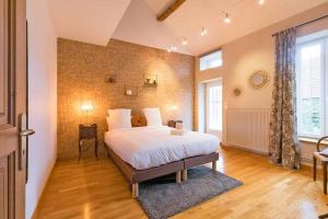 Un dormitorio con una cama grande en una habitación. en Maison Saint Agnan, en Ahuy