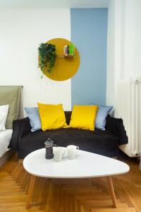 salon z czarną kanapą i żółtymi poduszkami w obiekcie KUKAKI ESTATE 1 w Atenach