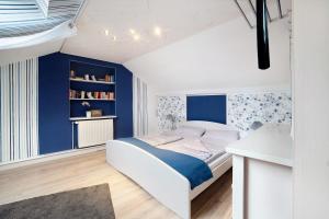 een slaapkamer met blauwe muren en een wit bed bij Haus Ruth in Hörden