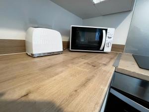 eine Mikrowelle auf einer Theke neben einem Toaster in der Unterkunft Central flat, Alton Towers, Waterworld in Stoke on Trent