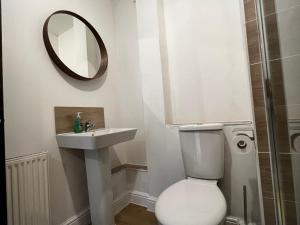 ein Badezimmer mit einem WC, einem Waschbecken und einem Spiegel in der Unterkunft Central flat, Alton Towers, Waterworld in Stoke on Trent